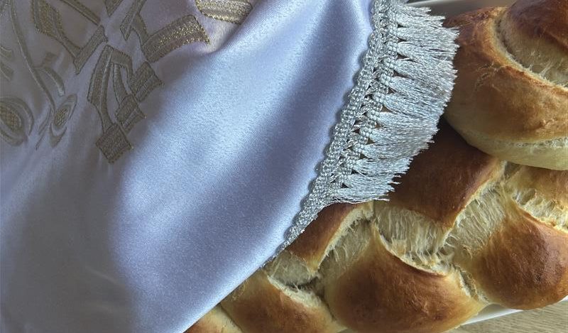 close up of fresh bread under a white cloth